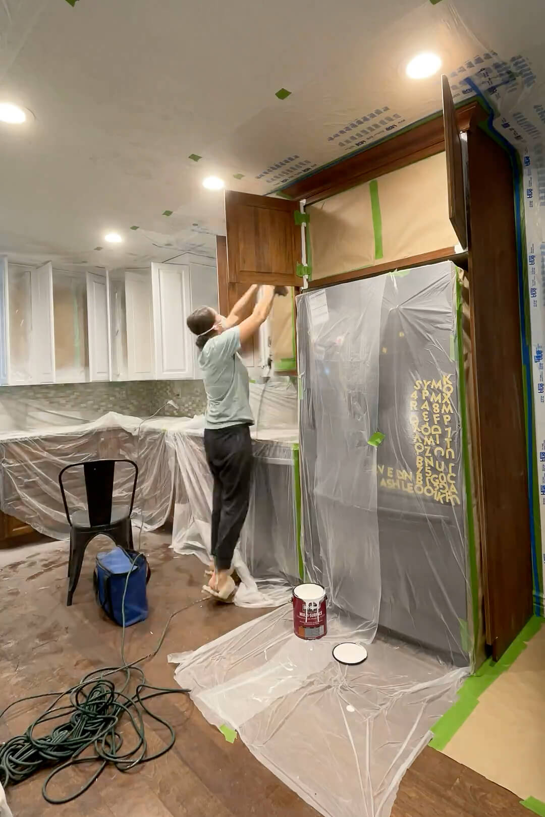 Painting kitchen cabinets with a paint sprayer and cabinet paint.