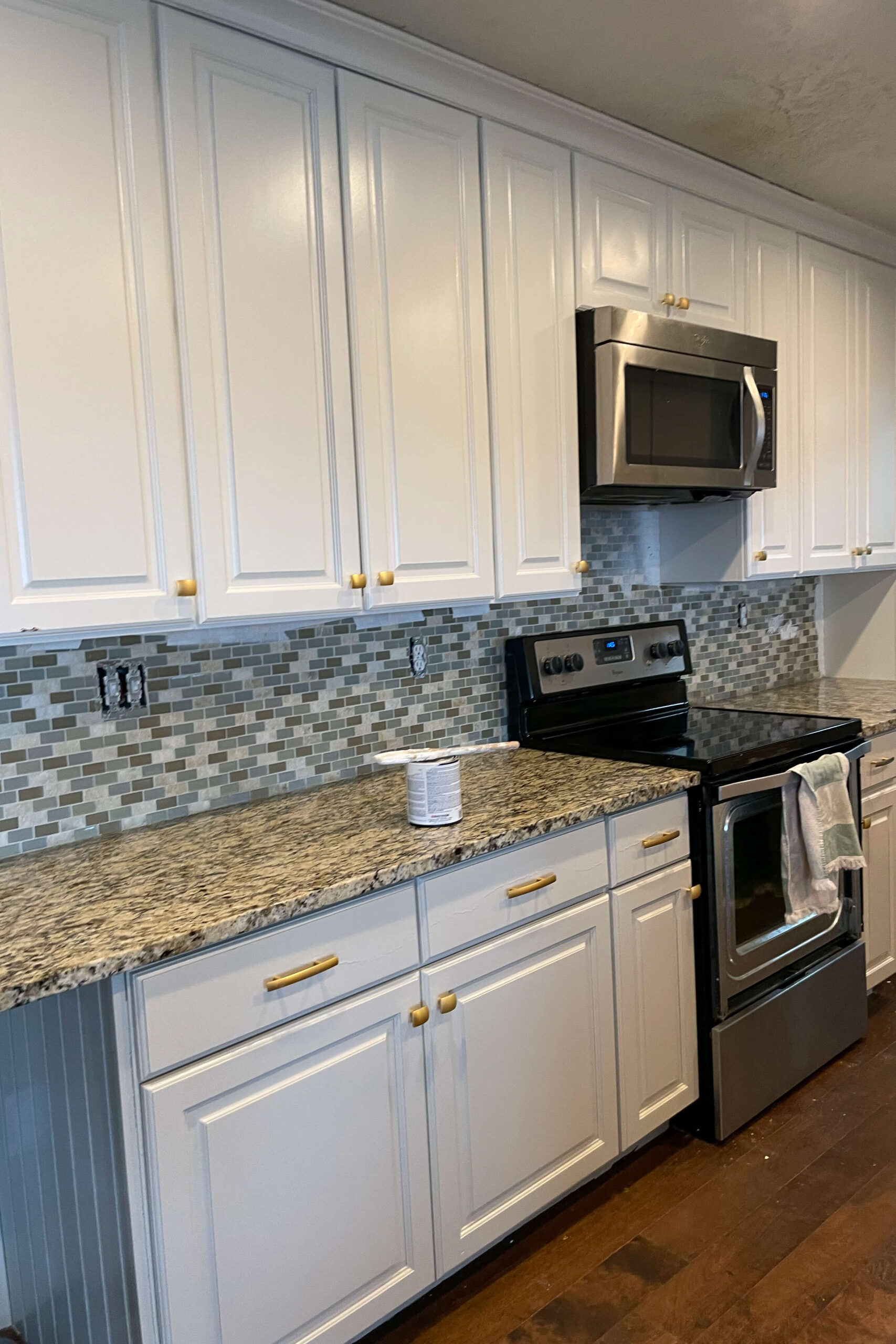 In progress photo of painting upper and lower kitchen cabinets different colors of cabinet paint.