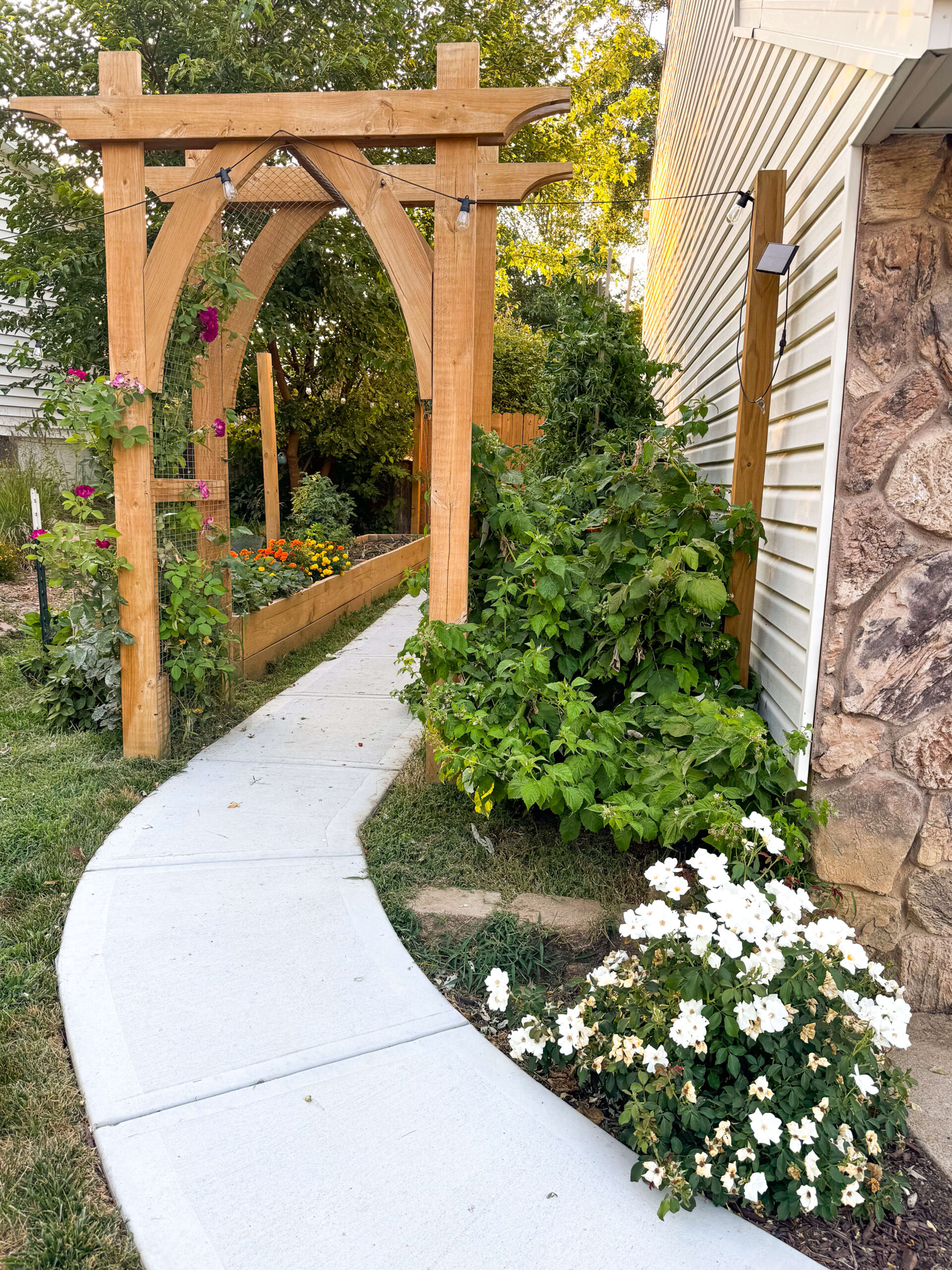 Yard designs and landscaping for a side yard beautifully executed with a garden arbor.