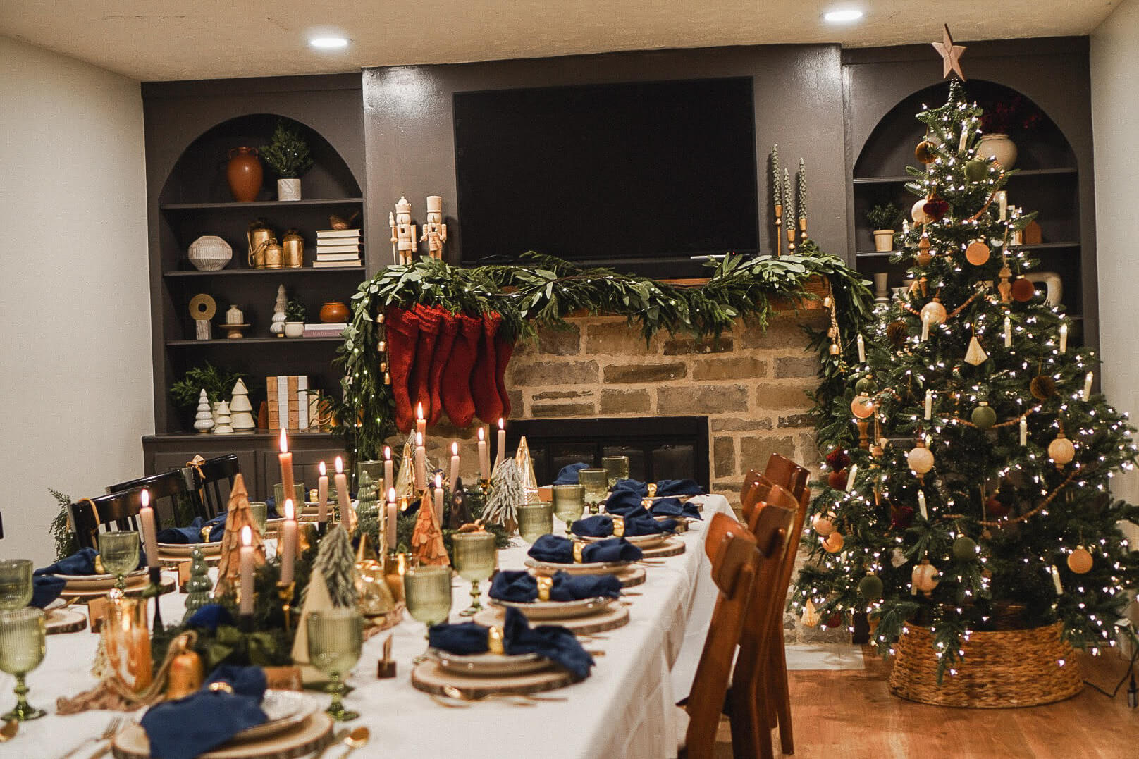 Gorgeous Christmas table set up for Christmas dinner in front of a stone fireplace.