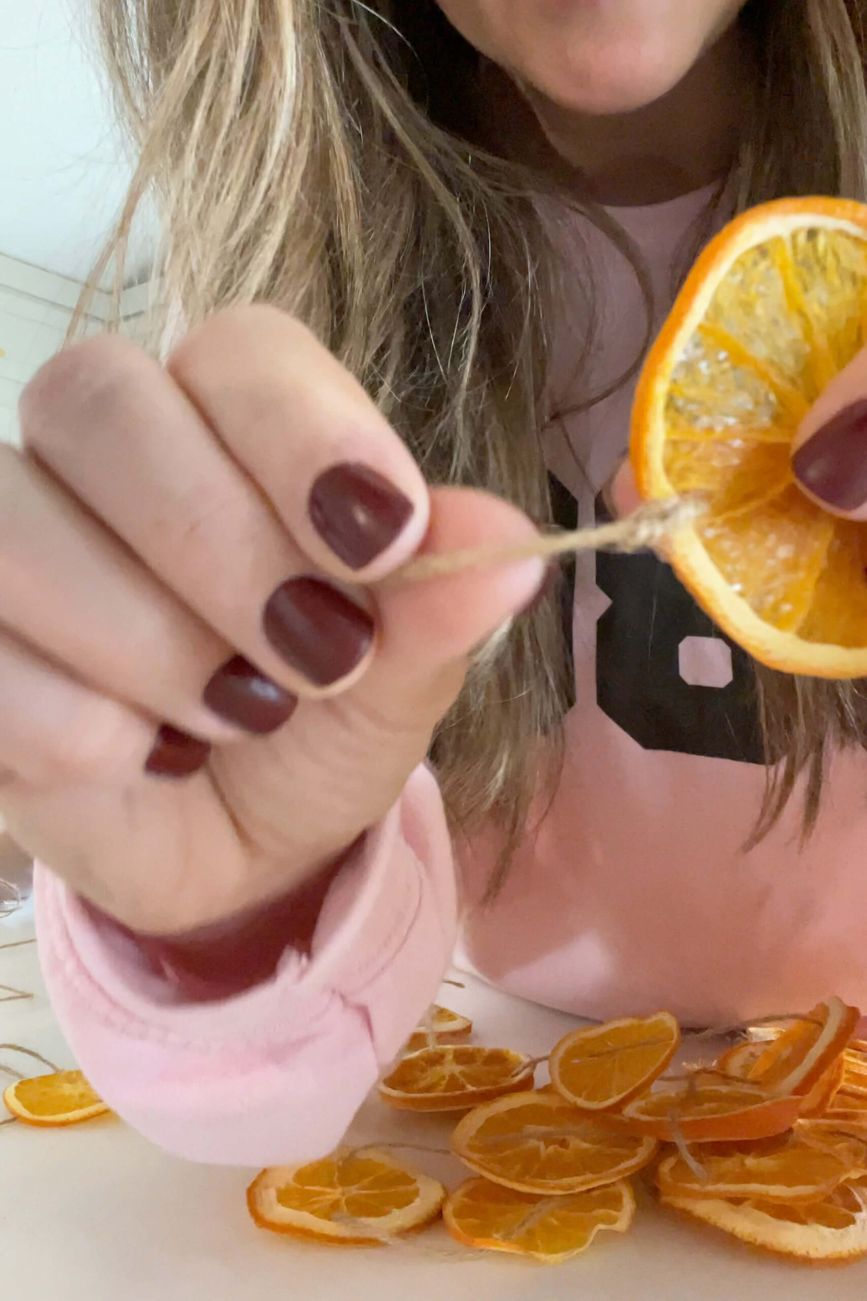 Starting an orange slice garland for decorating a stair banister.