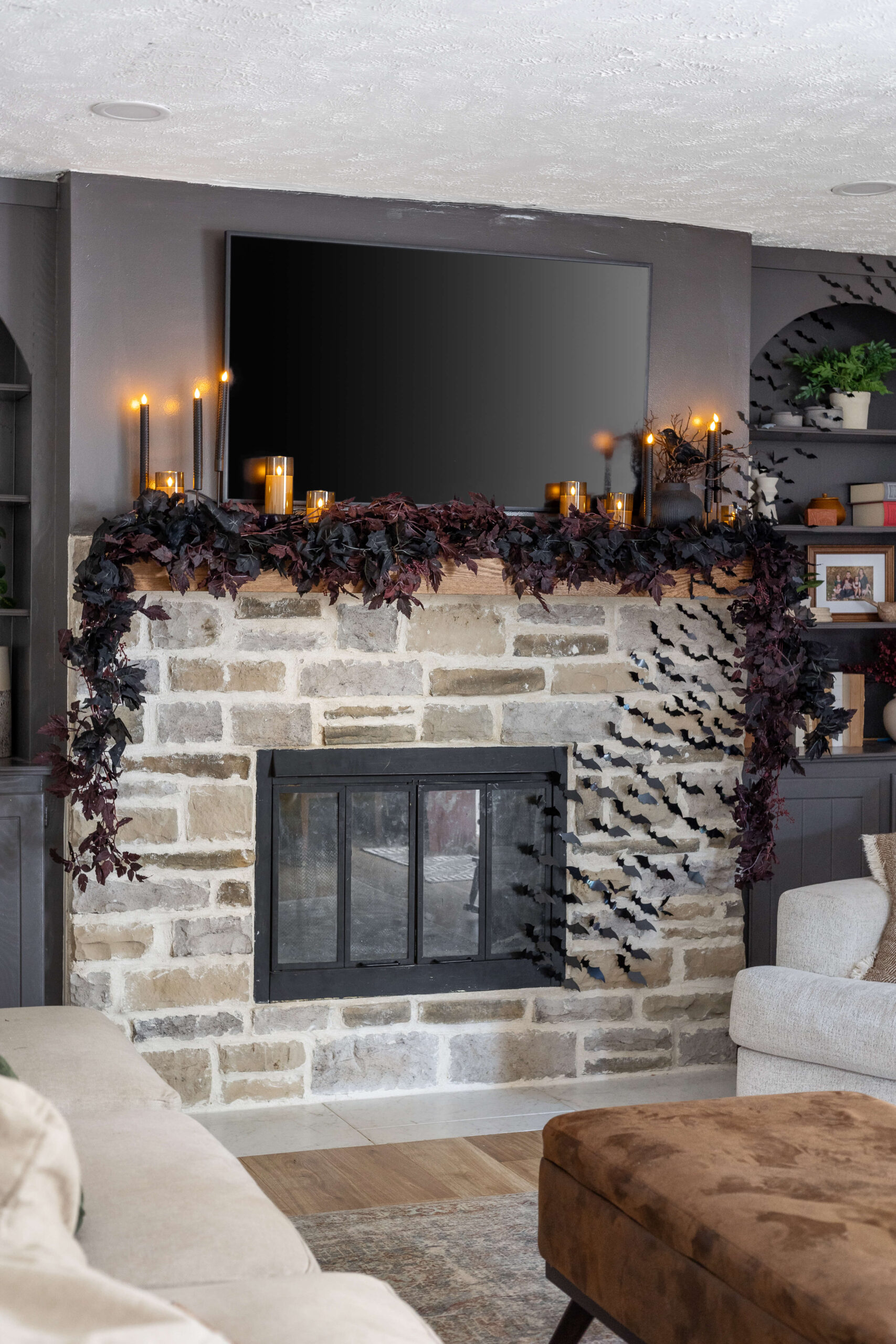 Cozy and dark living room with elegant Halloween decor on the mantel.