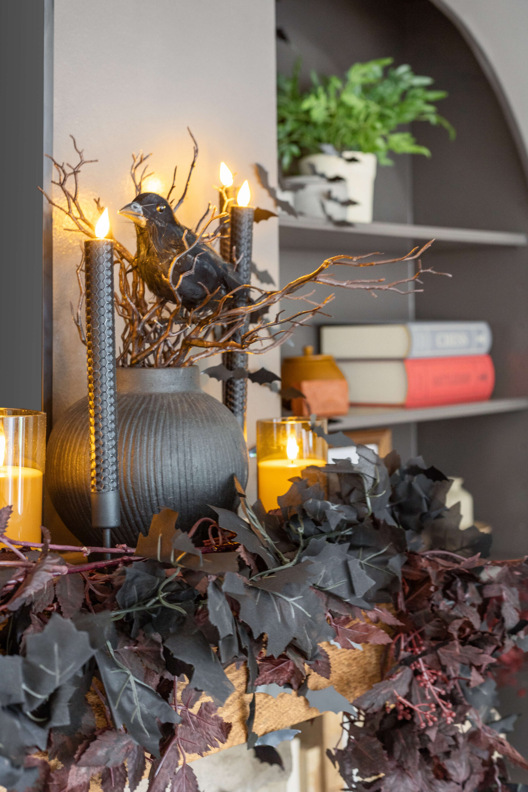 Fireplace mantel with spooky candles, and dark garlands. 