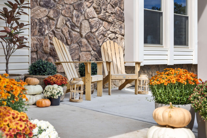 Classic fall front porch decorations using mums and pumpkins.