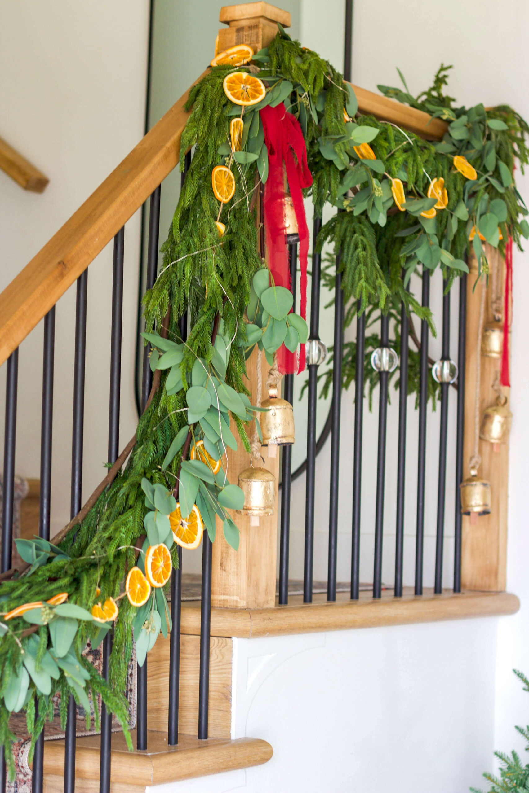 The best and most realistic pine garland mixed with eucalyptus garland and orange slice garland on a stair railing.