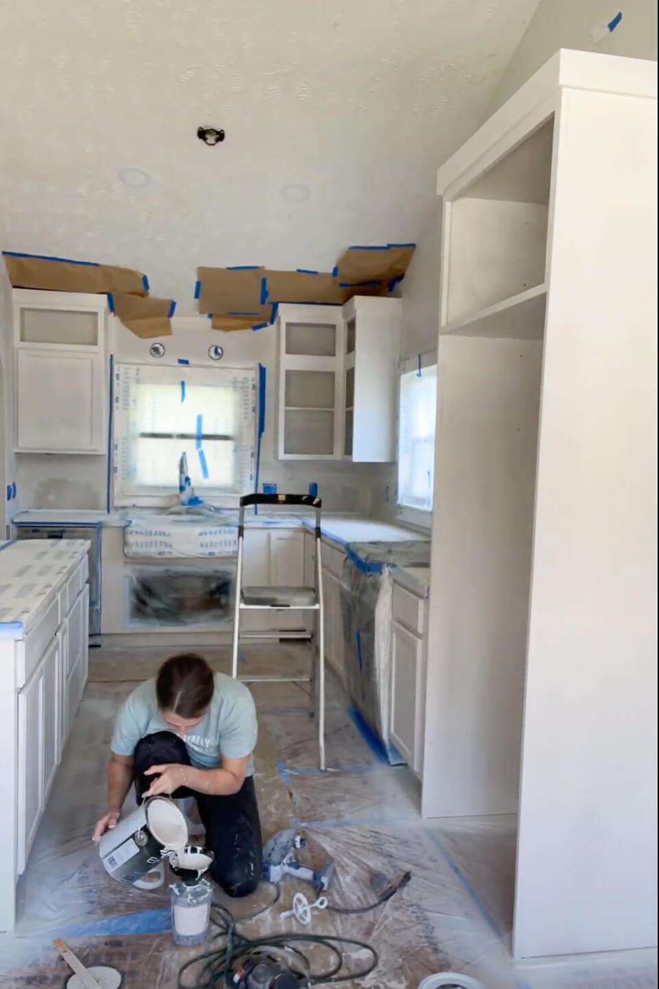 Painting kitchen cabinets with a paint sprayer.