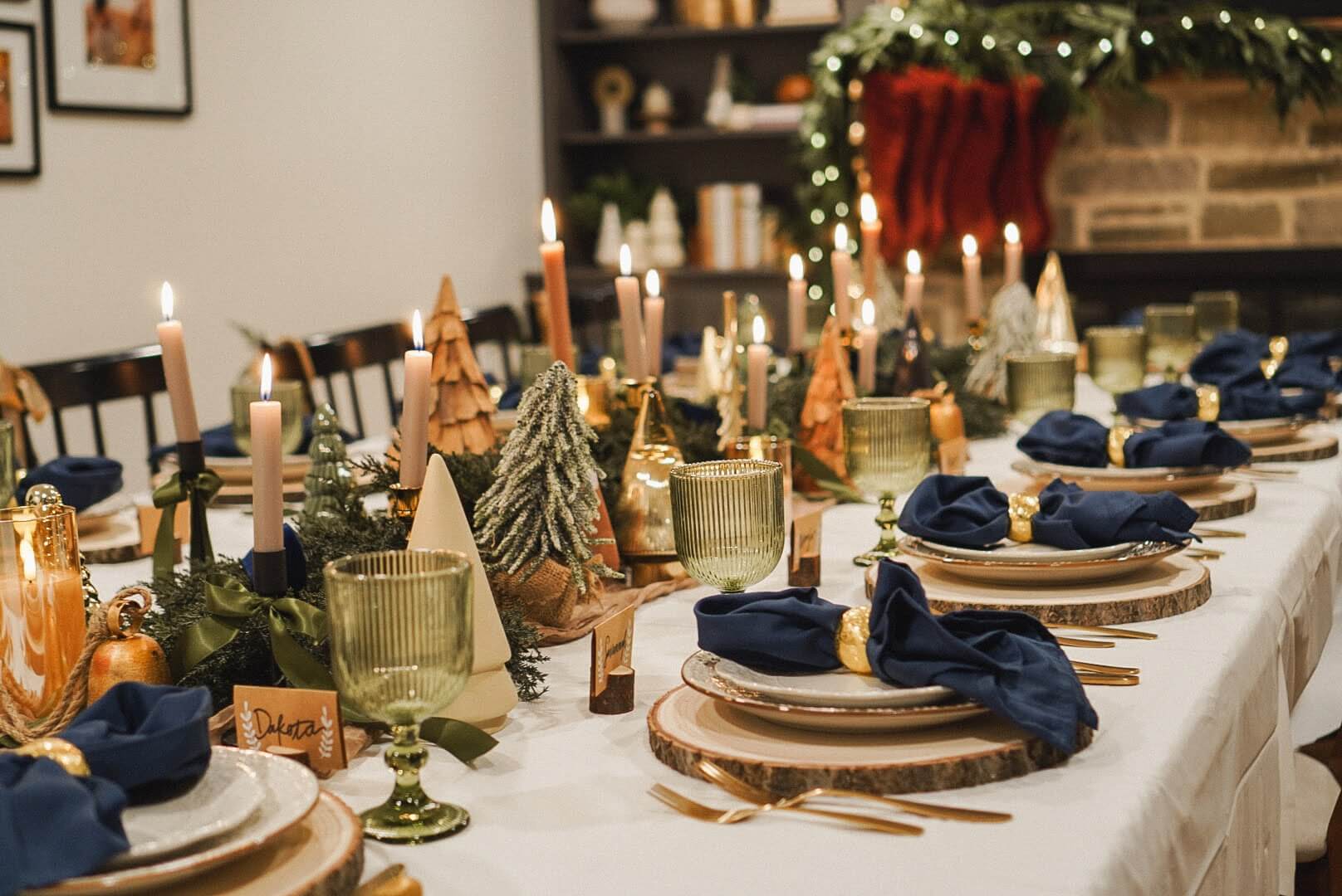 Close-up of Christmas tablescape candles and decorative elements, including gold bells and greenery, creating a cozy holiday atmosphere.