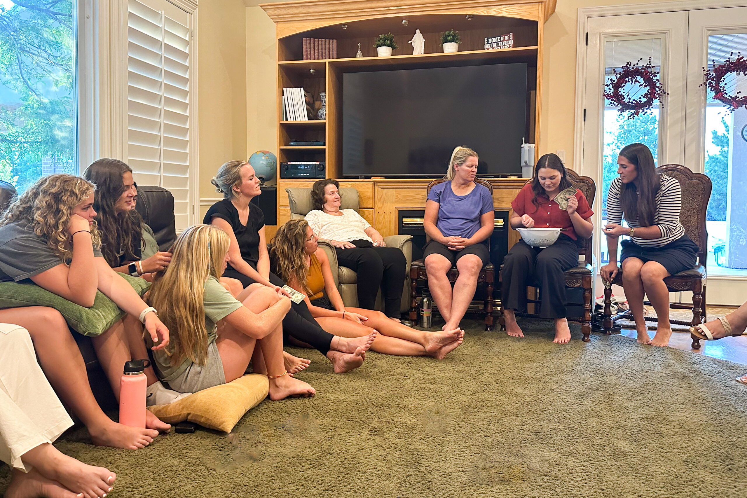 Family and friends sitting together indoors, engaging in fun christmas party games during a holiday gathering.