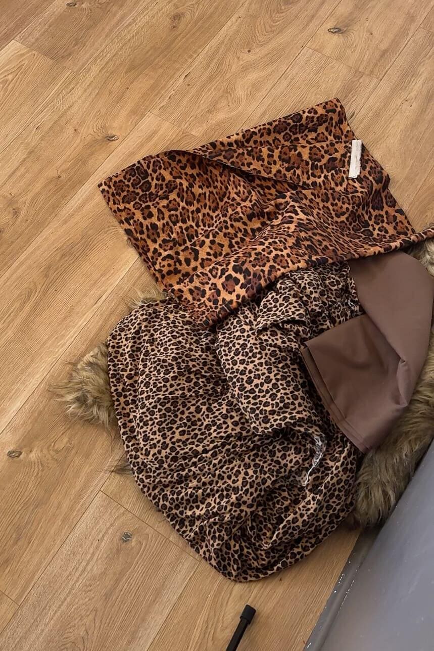 Leopard prints, brown fabric, and faux fur laid out for DIY costumes.