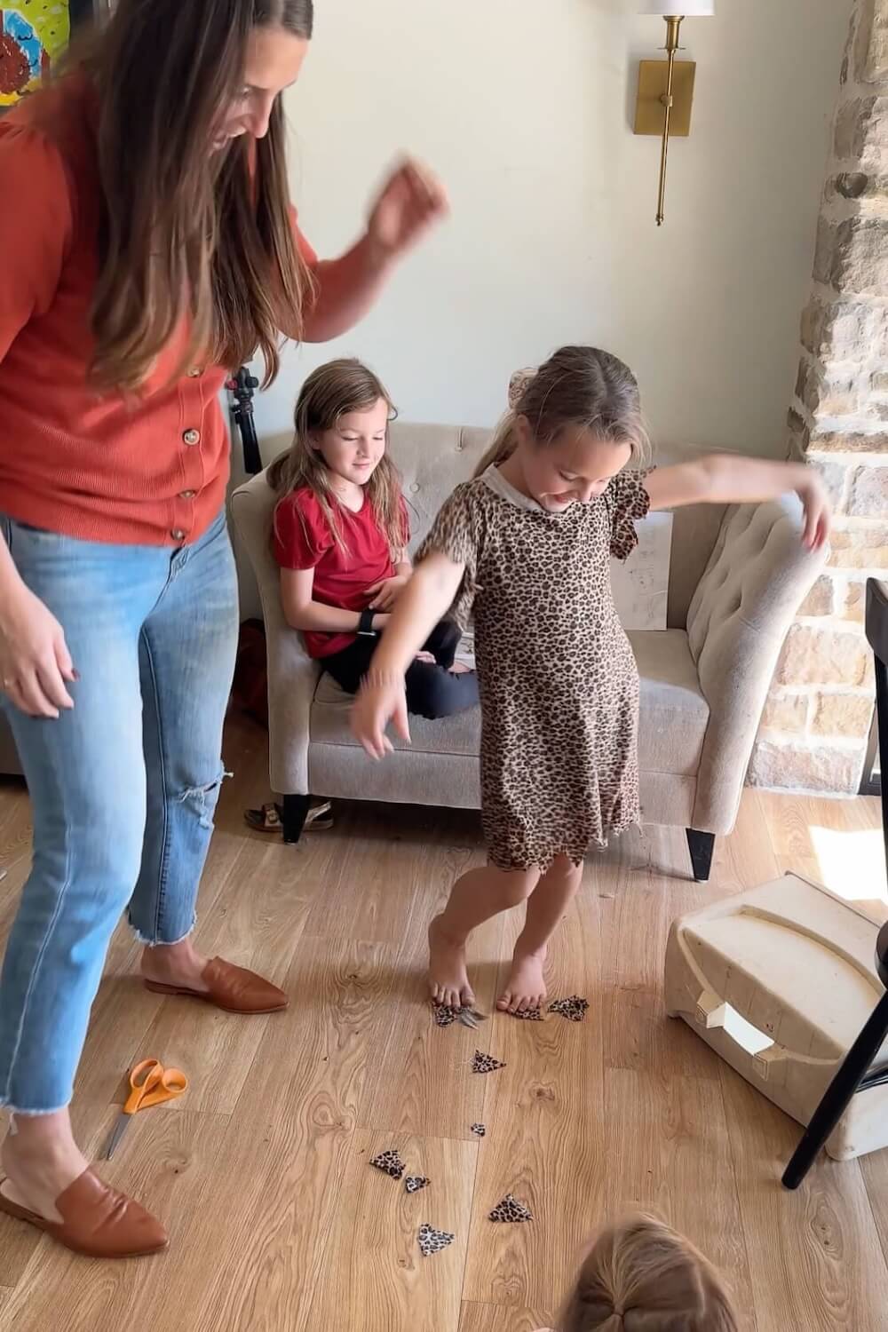 Child twirling in homemade caveman tunic while mom trims fabric