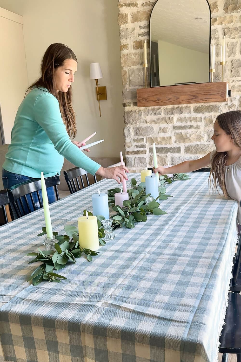 DIY Easter table centerpiece made with eucalyptus garland, pastel taper candles, and faux speckled eggs