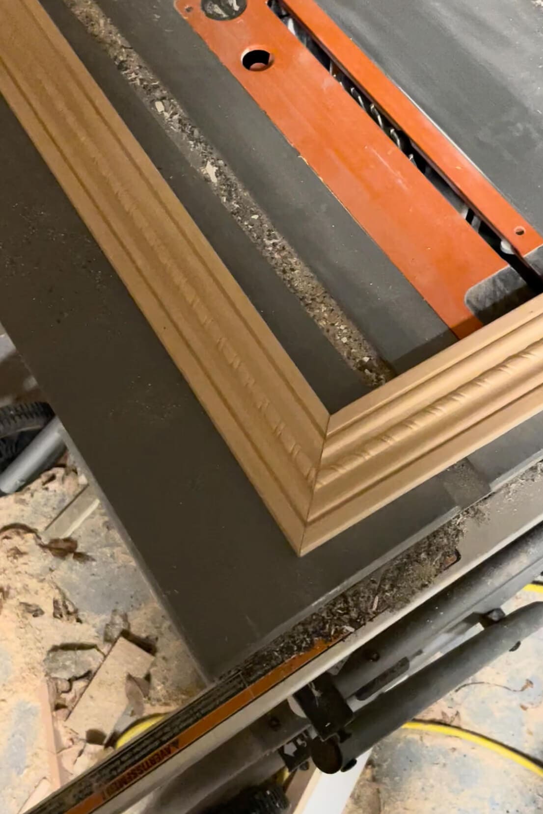 Mitered frame corners laid out on a table saw during the DIY frame-building process.