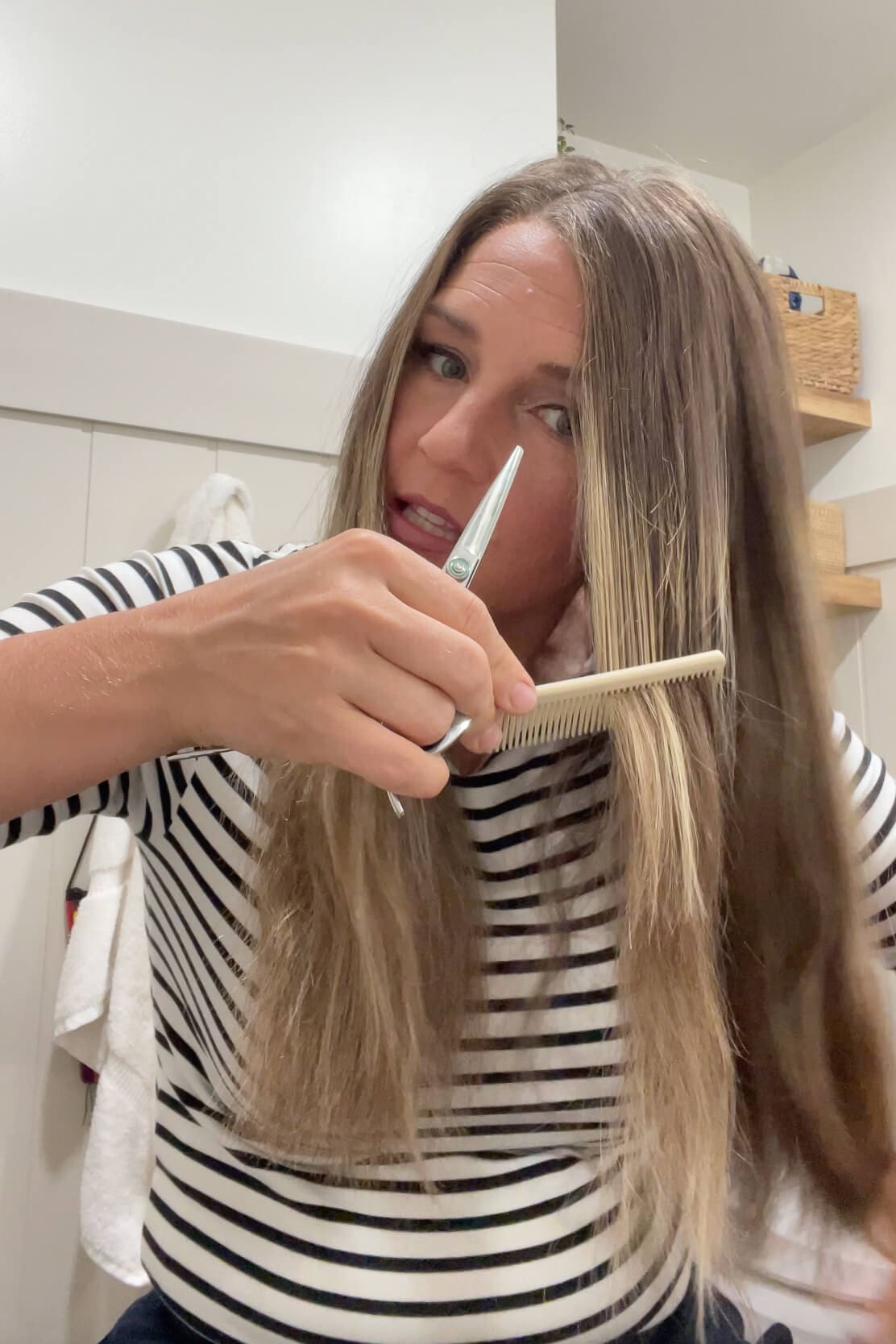 Using a comb and scissors to trim angled layers around the face for a DIY layered haircut.