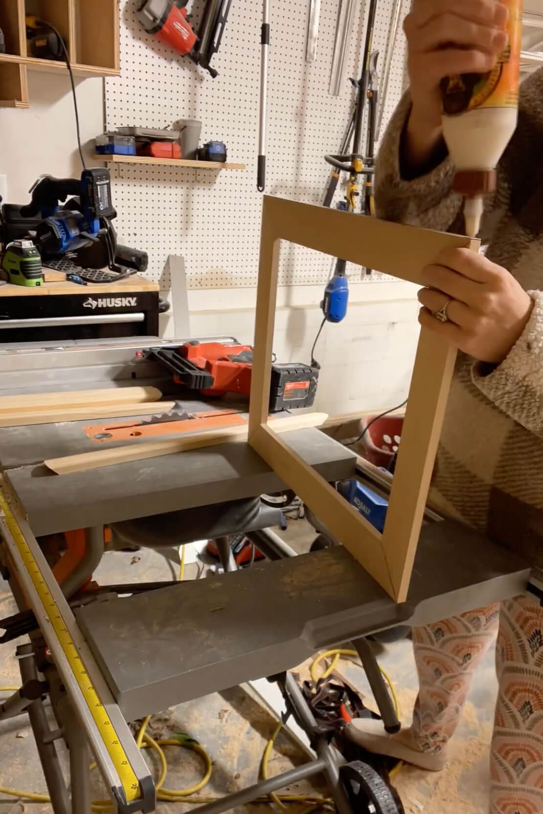 Gluing the corners of a custom DIY frame as part of a homemade Father’s Day canvas gift project.