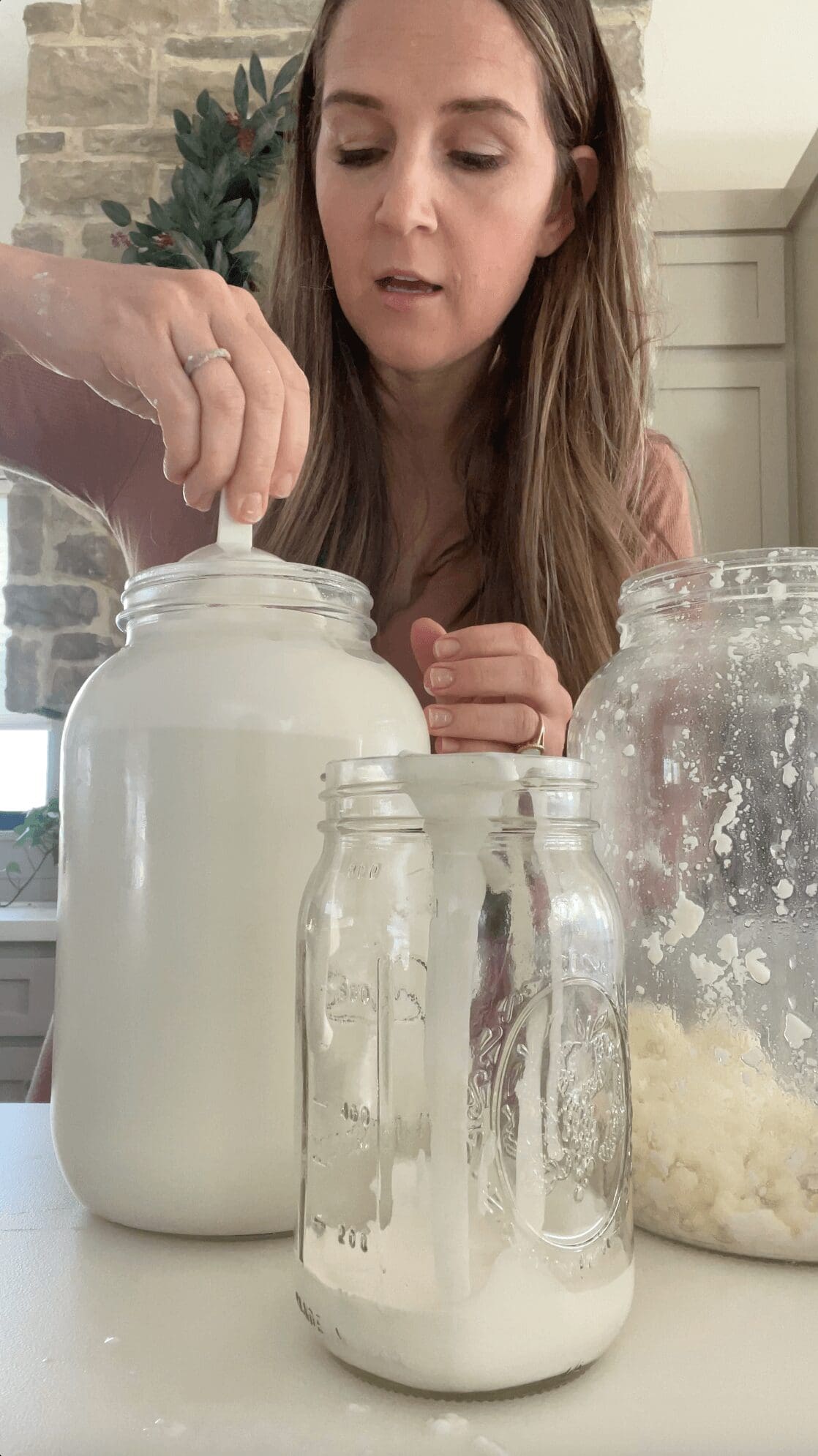 Scooping the thick cream layer off the top of raw milk.