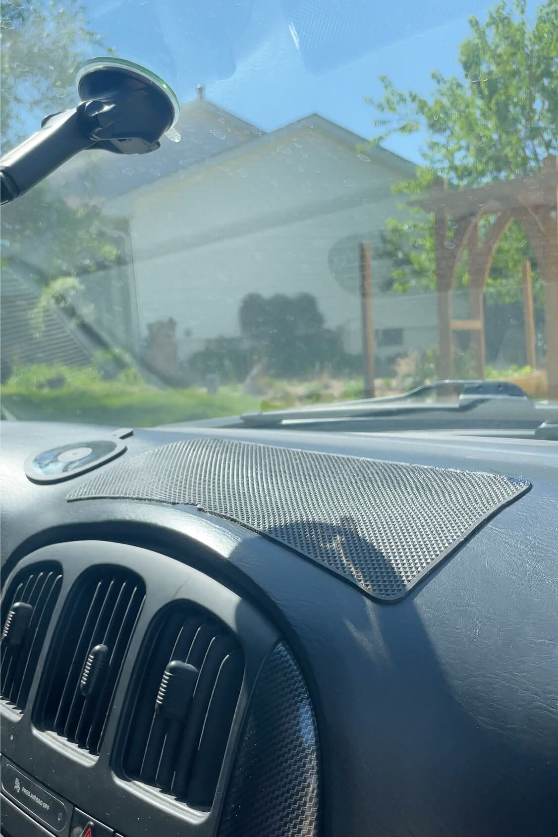 Sticky rubber grip mat placed on a car dashboard to keep phones or small items from sliding during drives.