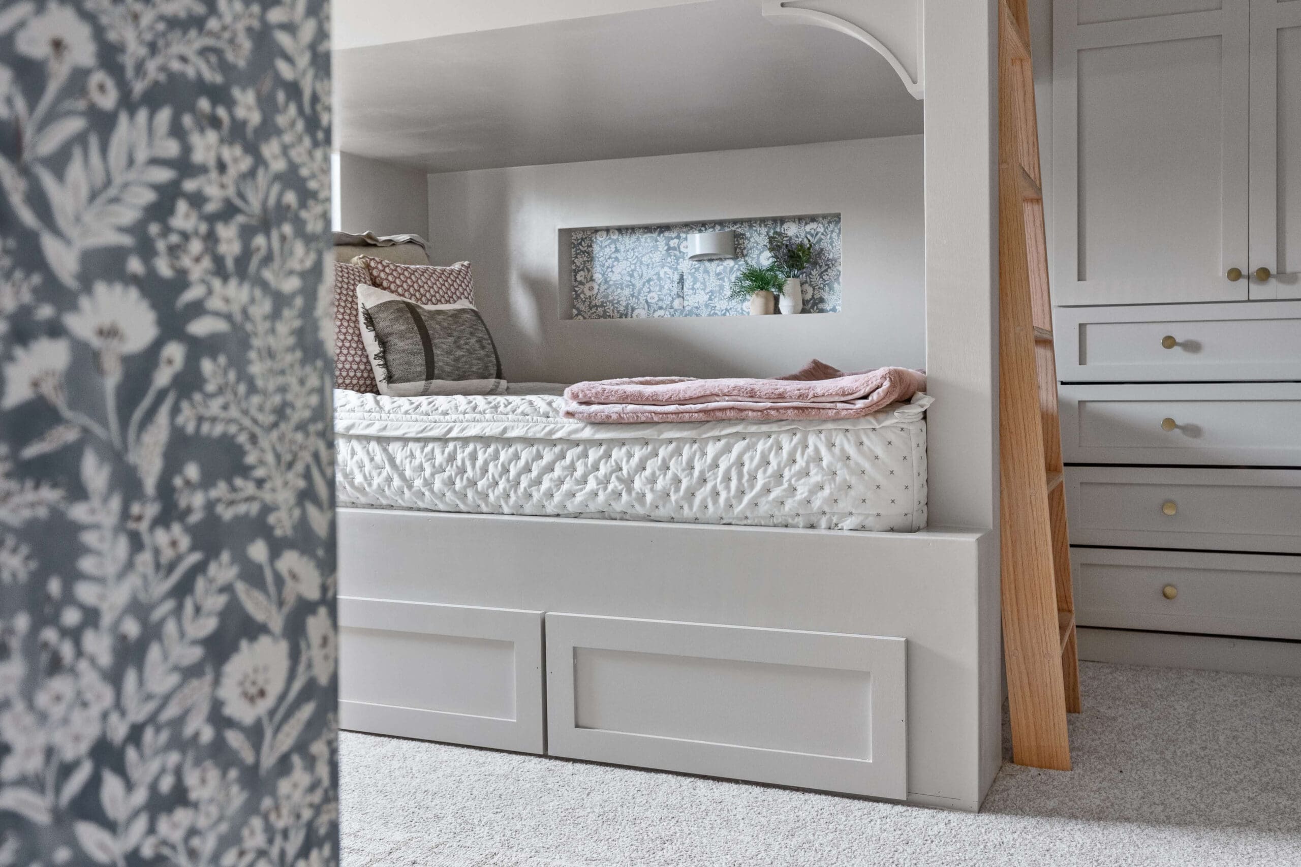 Zoomed-out view of a custom built-in bunk bed with a wallpapered wall niche, showcasing how the outlet cover blends into the wallpaper design.