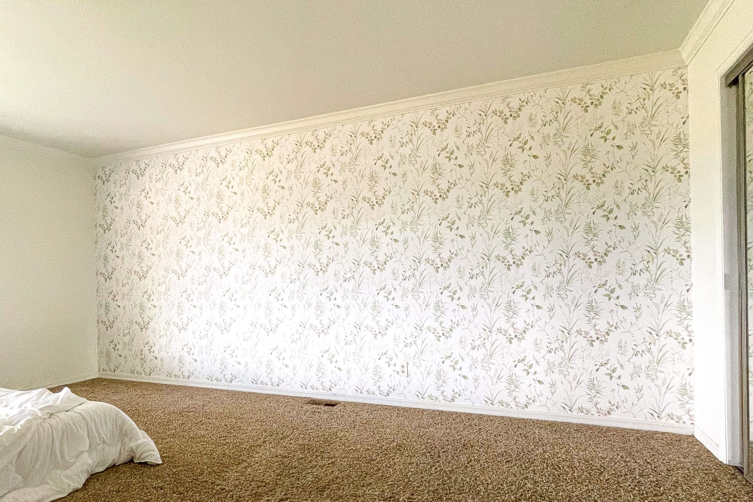 Full view of a completed bedroom feature wall with traditional botanical wallpaper