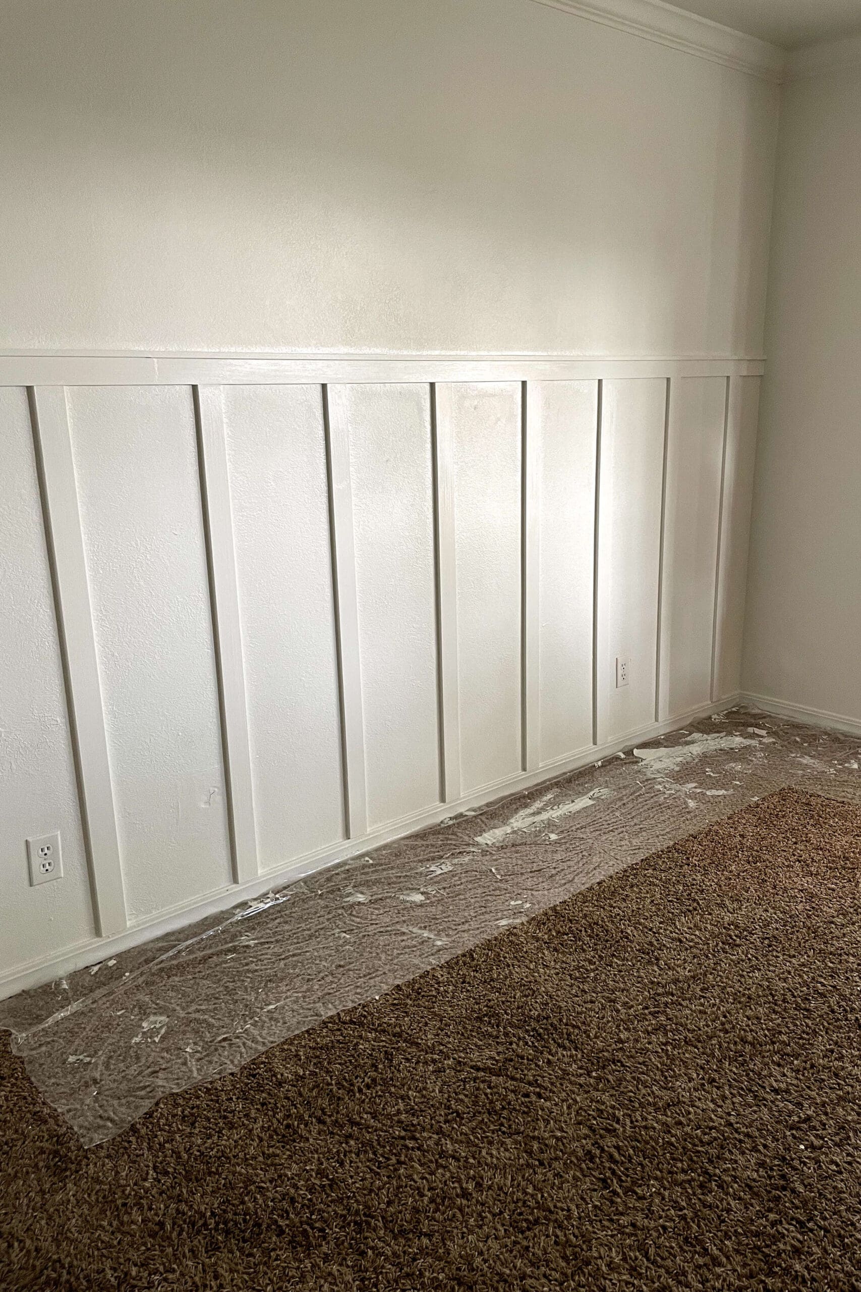Freshly painted board and batten accent wall with a smooth white finish, adding texture and dimension to the space.