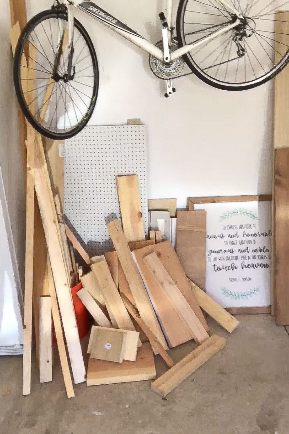 A pile of scrap wood stored in a garage, later used to build a handmade wooden bedframe for a child.