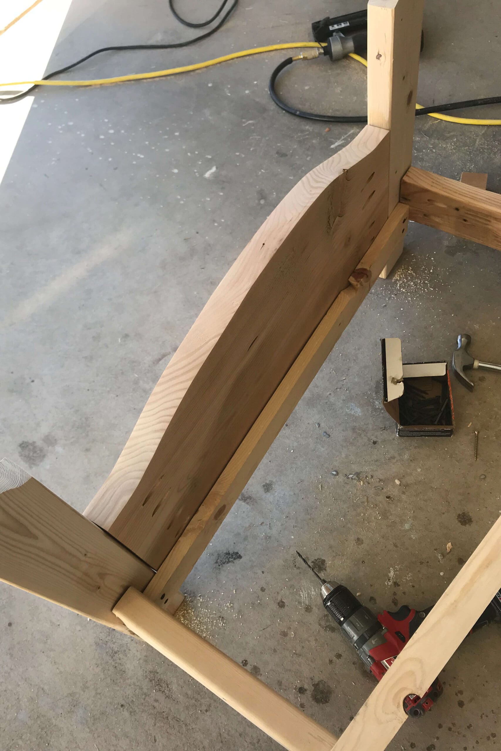 Detailed view of the bed corner showing the cleat installation used to support the mattress slats in this wooden DIY build.