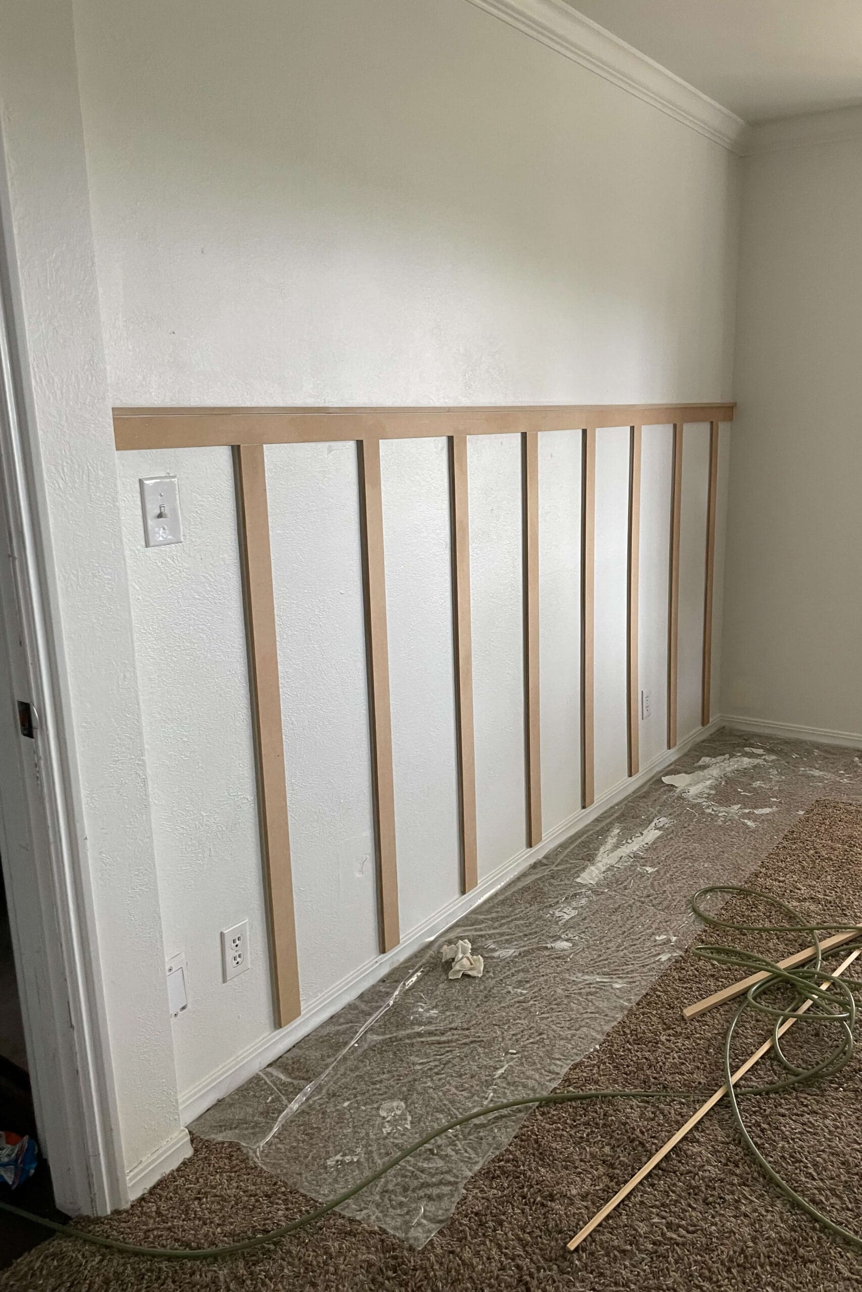 Board and batten wall fully installed and ready for primer and paint, showing clean lines and symmetrical spacing.