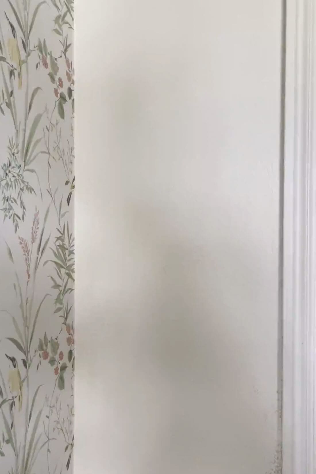 Clean wallpaper seam meeting a painted wall edge with door trim