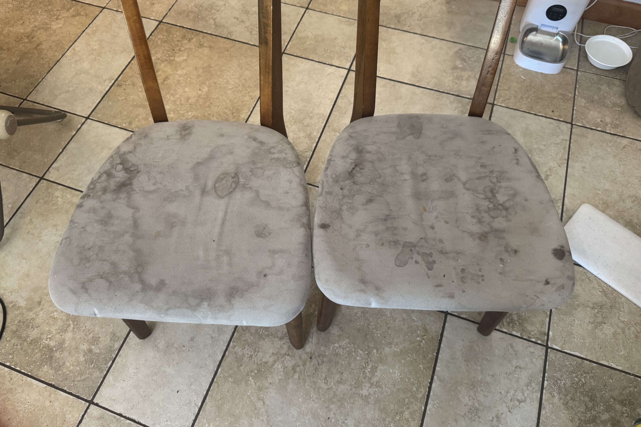 Two heavily stained upholstered seats with dark marks and water spots before.