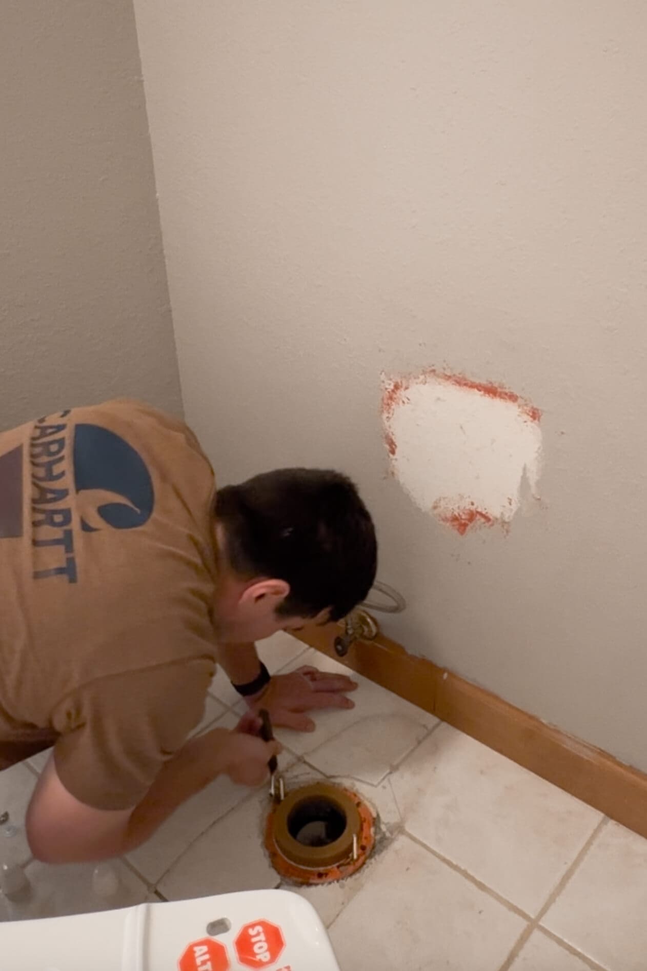 Man placing new closet bolts in a DIY bathroom renovation.