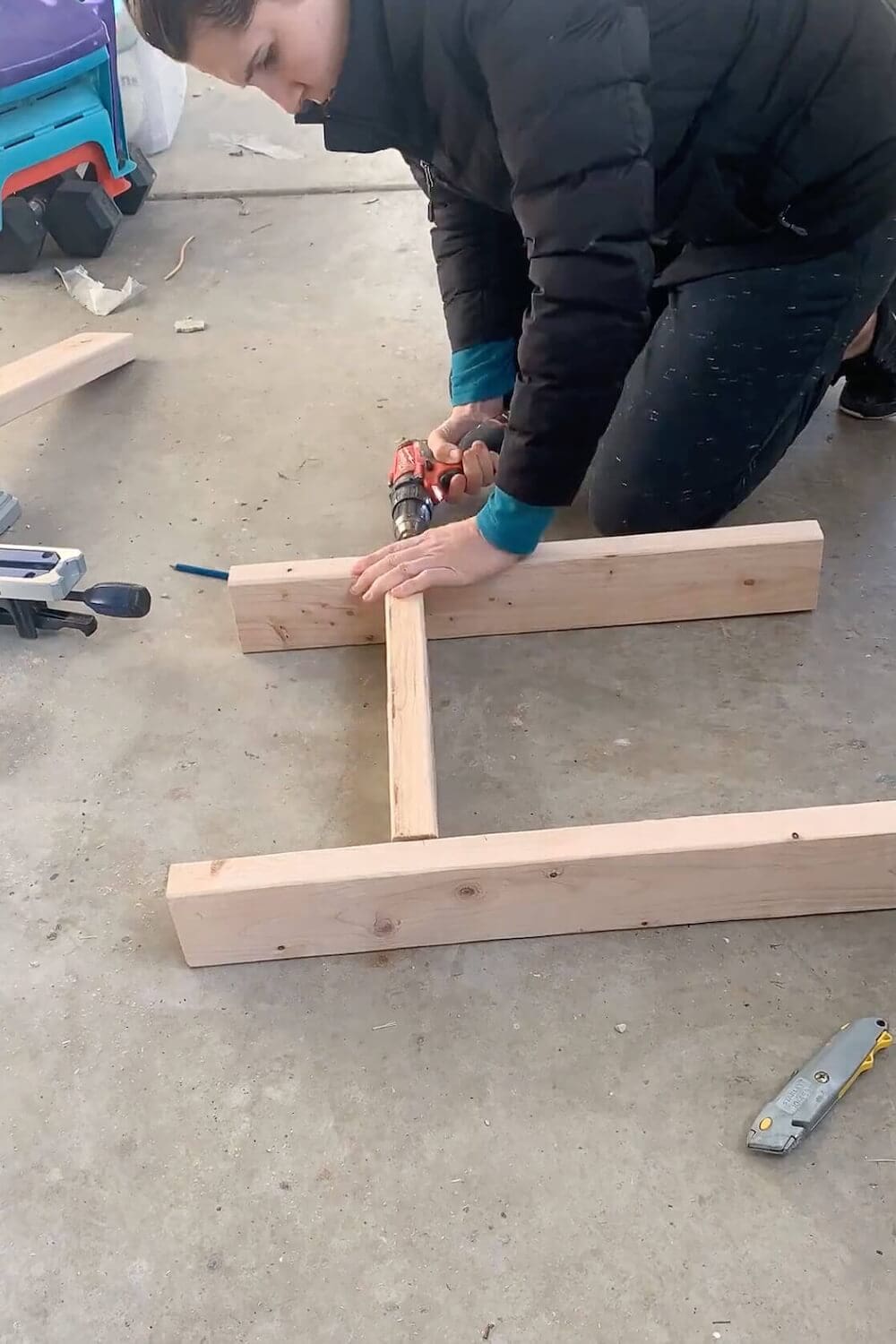 Assembling a wood frame for a shower niche on the floor during a basement bathroom remodel.
