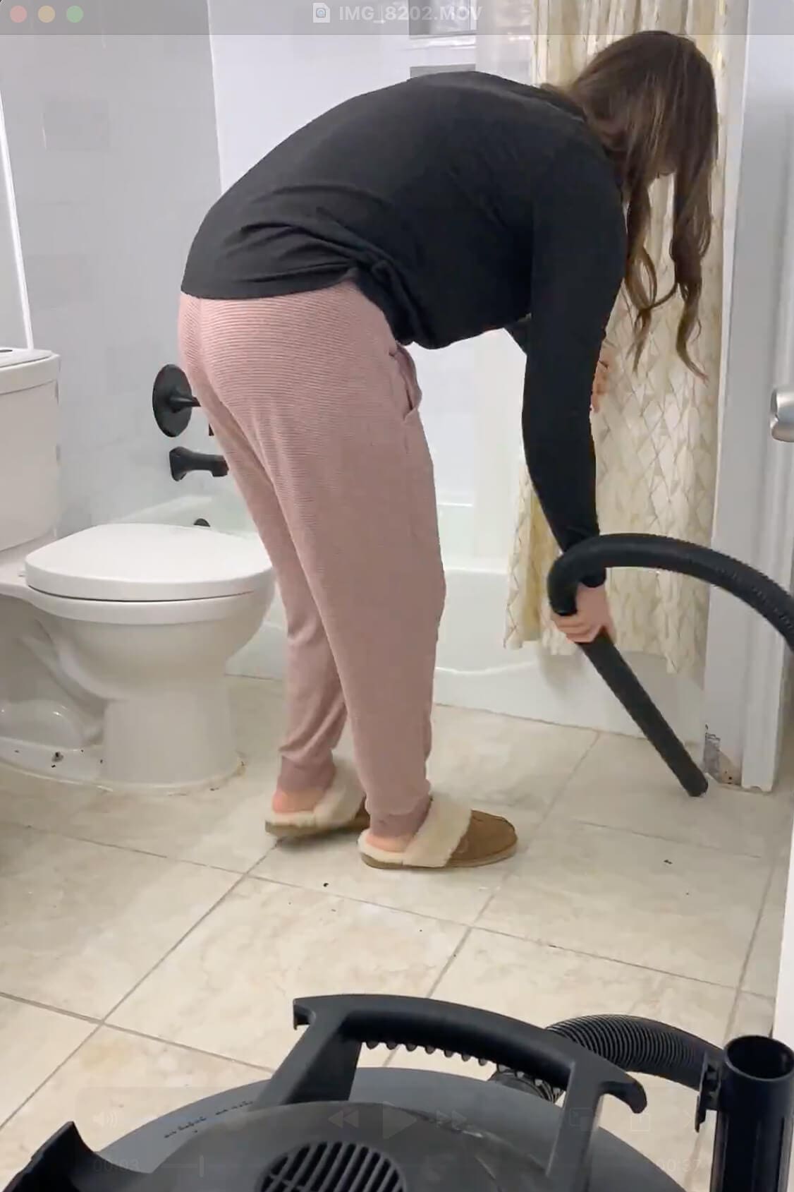 Vacuuming during prep and cleaning for paint, with dust removal around the toilet and shower area.