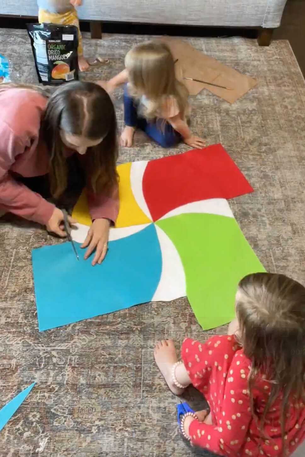 Cutting colorful felt pieces to form the swirl design for a DIY lollipop candy costume.