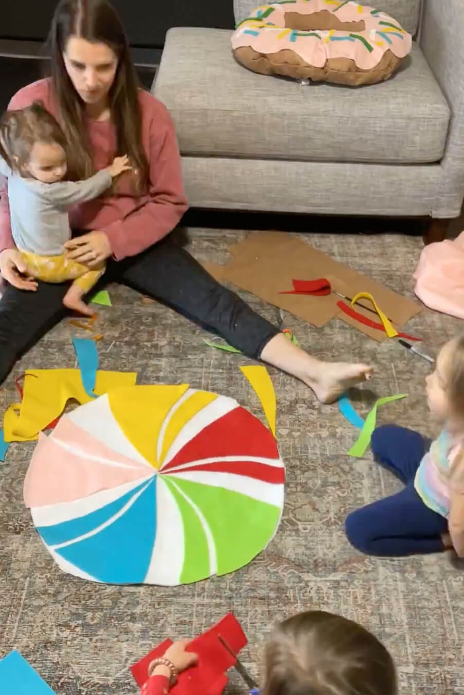 Brightly colored DIY lollipop candy costume with red, yellow, green, and blue swirl pieces assembled together.