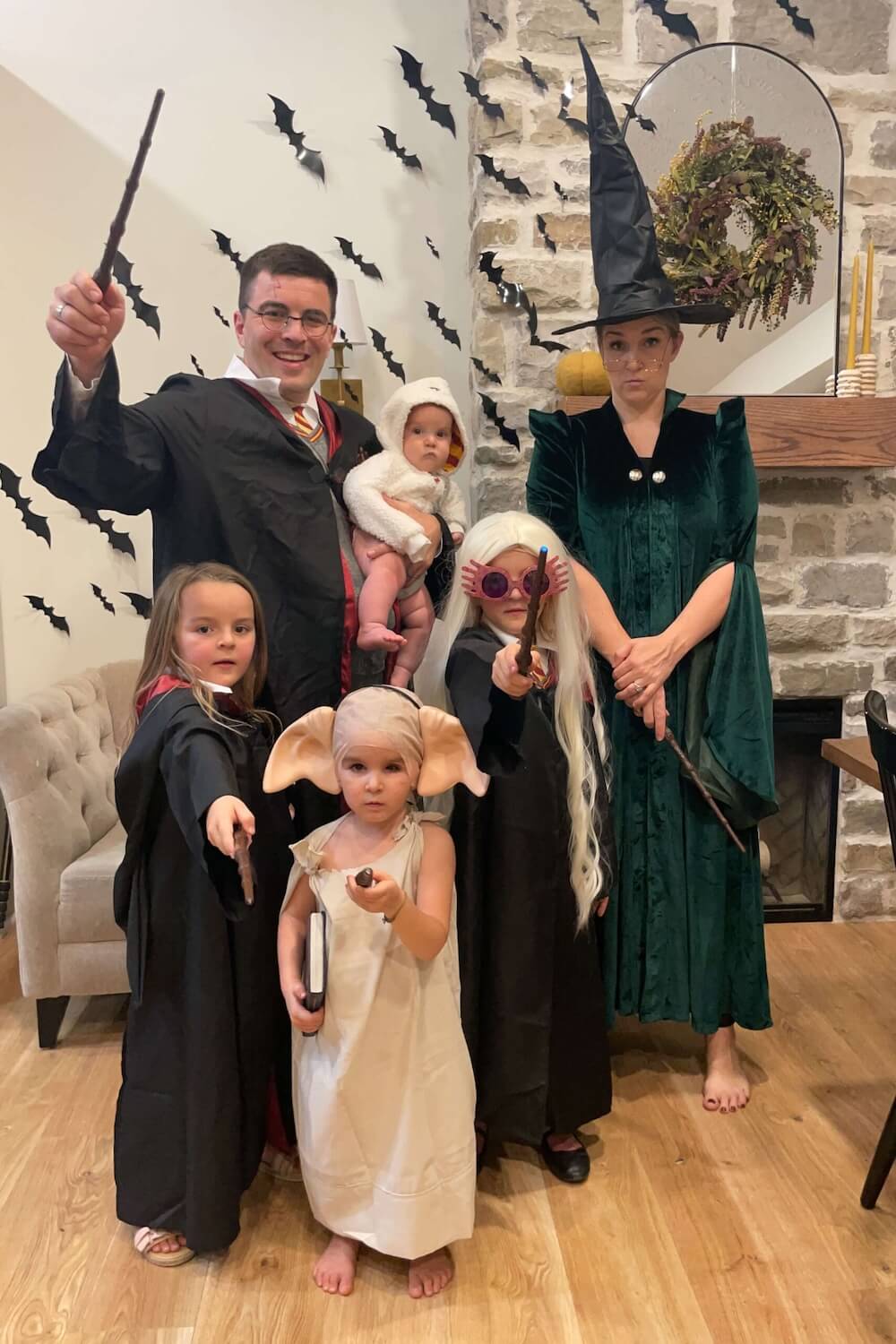 amily in Harry Potter themed costumes posing with wands, including Harry, Hermione, Luna Lovegood, Dobby, Hedwig, and Professor McGonagall.