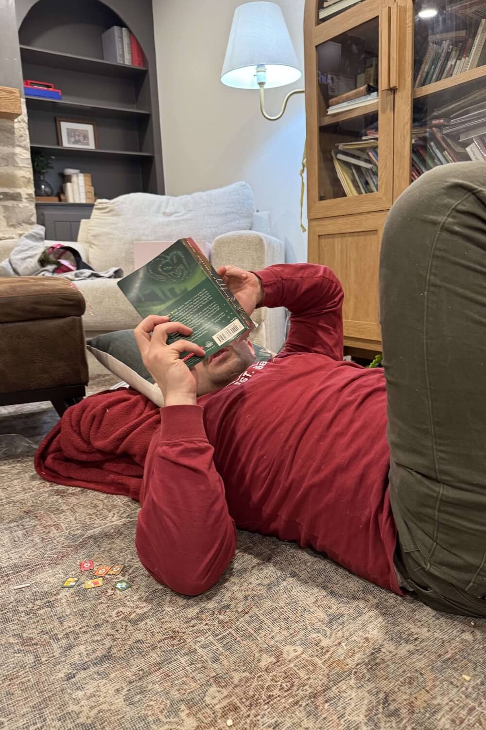 Father reading a Harry Potter book out loud at home, part of family tradition of bedtime reading.