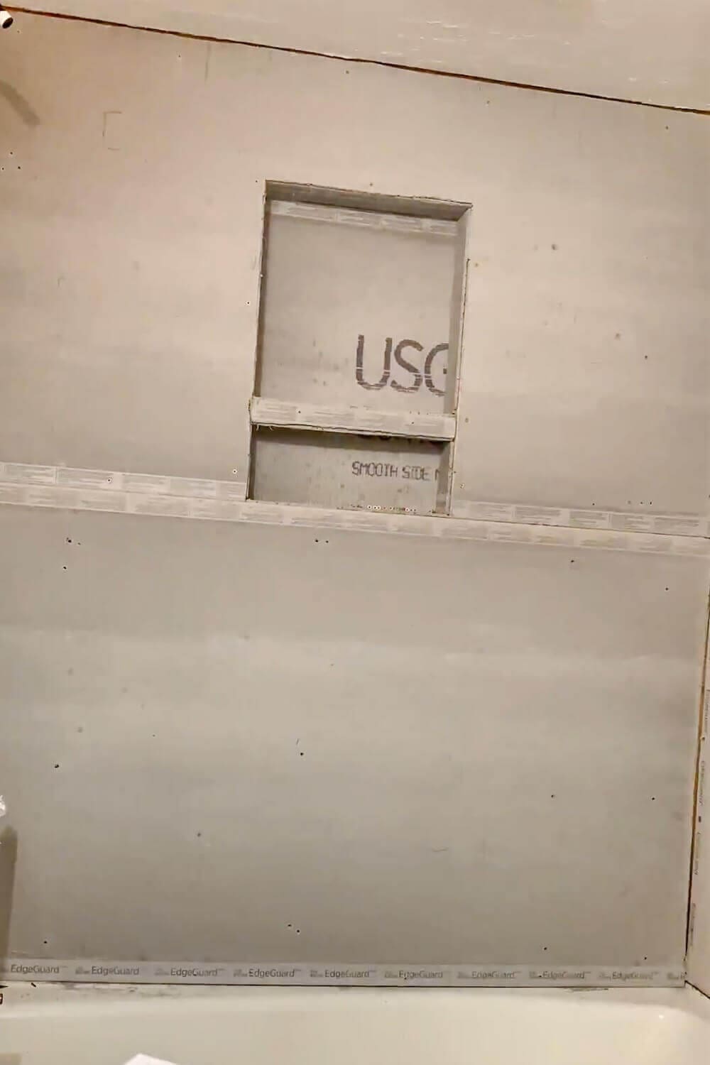 Rough framing for a shower niche installed in the wall, showing 2×4 studs and niche cavity before backer board.