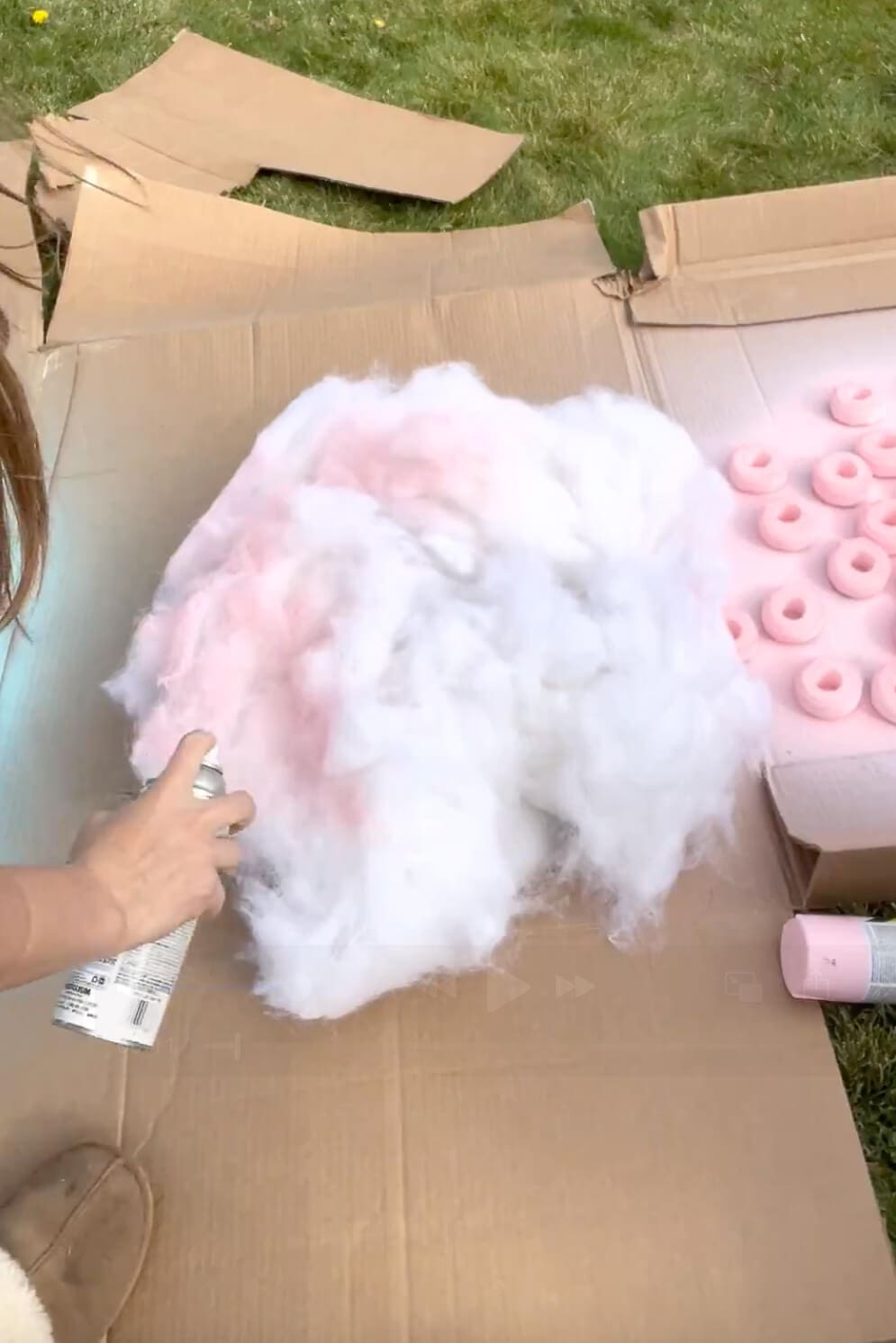 Spray painting polyester batting pink to create fluffy material for a DIY cotton candy costume.