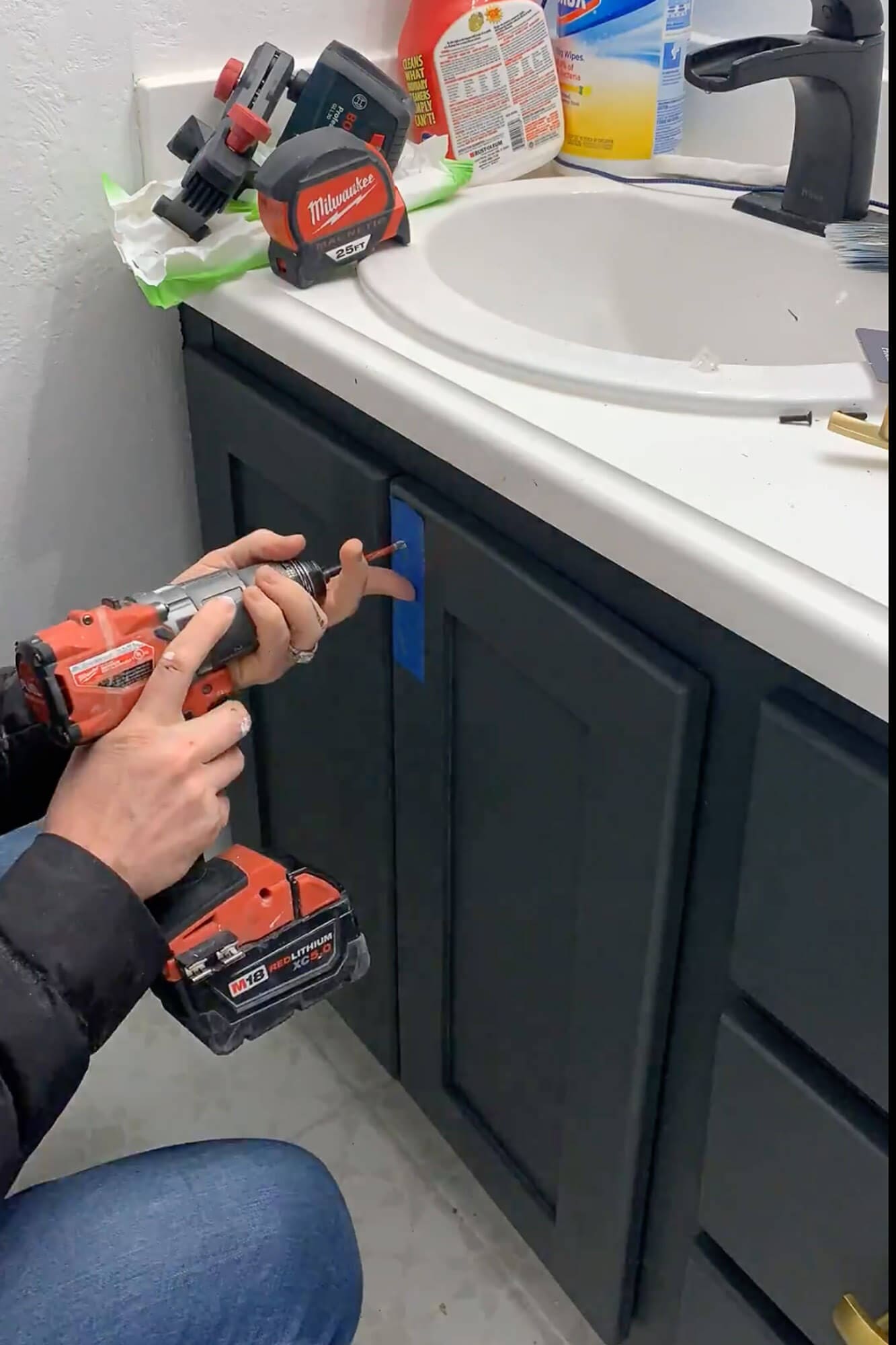 Drilling holes for bathroom vanity hardware using painter’s tape as a guide