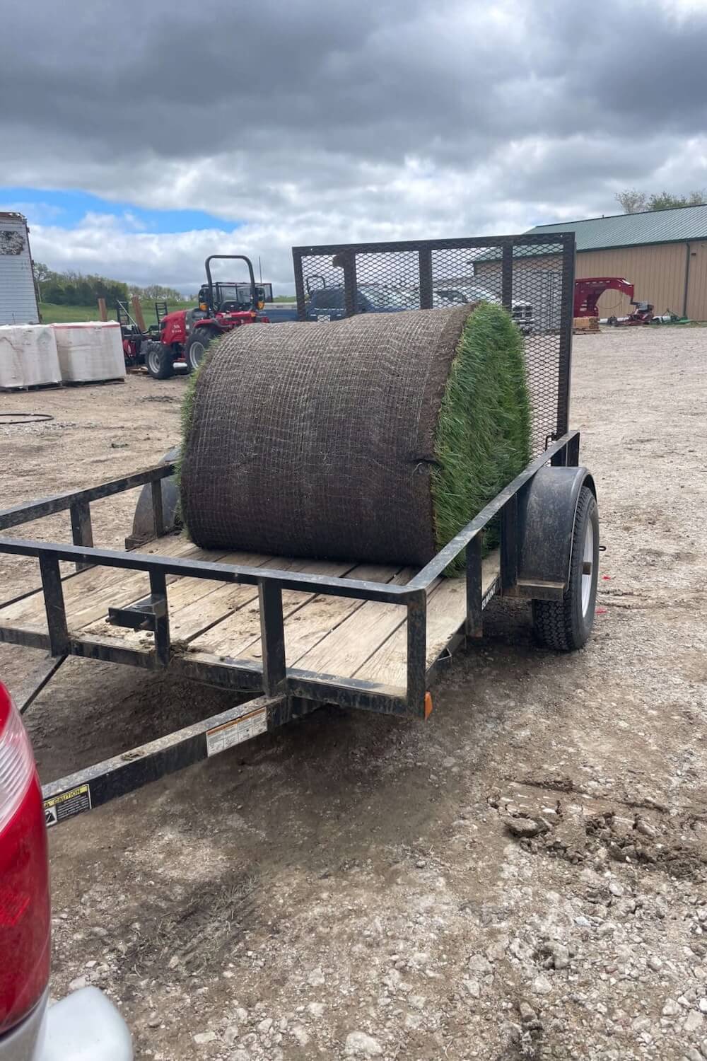 Picking up a giant roll of sod in a trailer.
