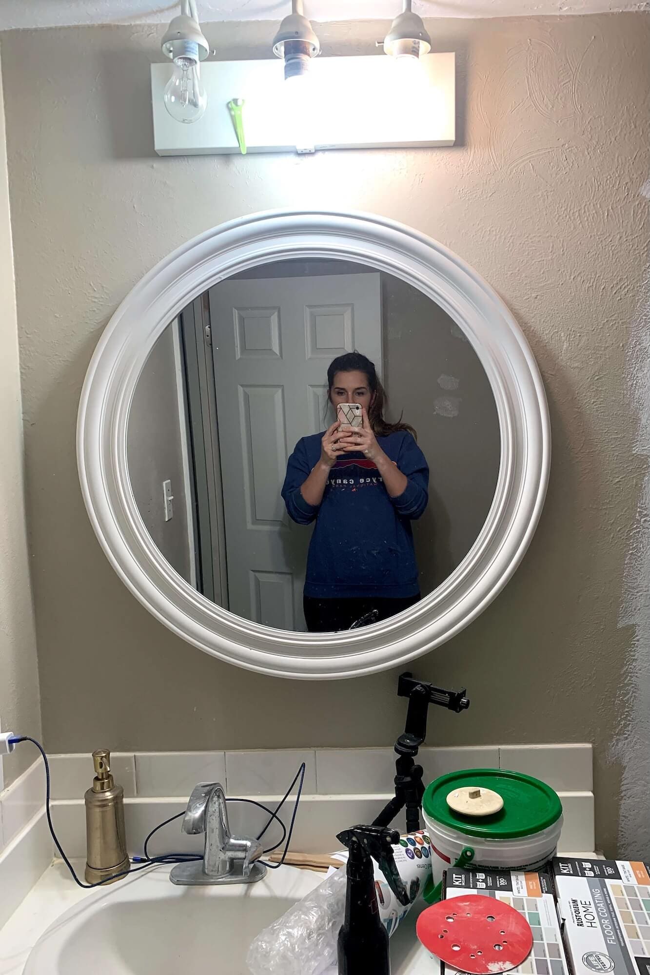 Round bathroom mirror with white frame before gold makeover