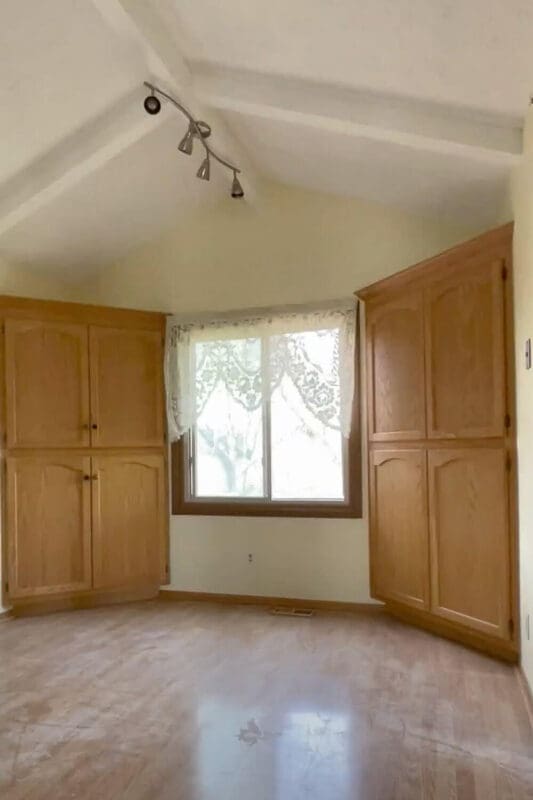 breakfast nook before remodel with oak built-in cabinets and lace curtain