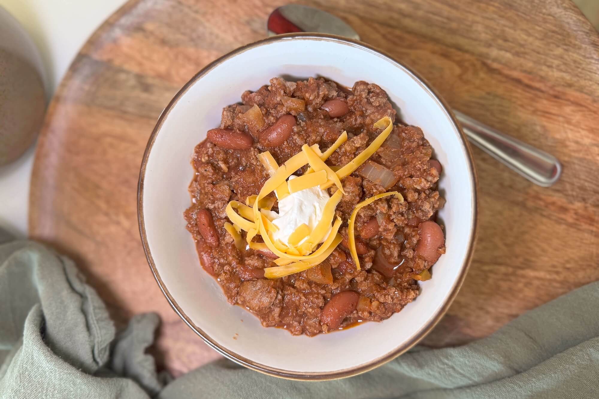 Classic beef and bean chili topped with shredded cheese and sour cream — perfect for football Sunday gatherings.