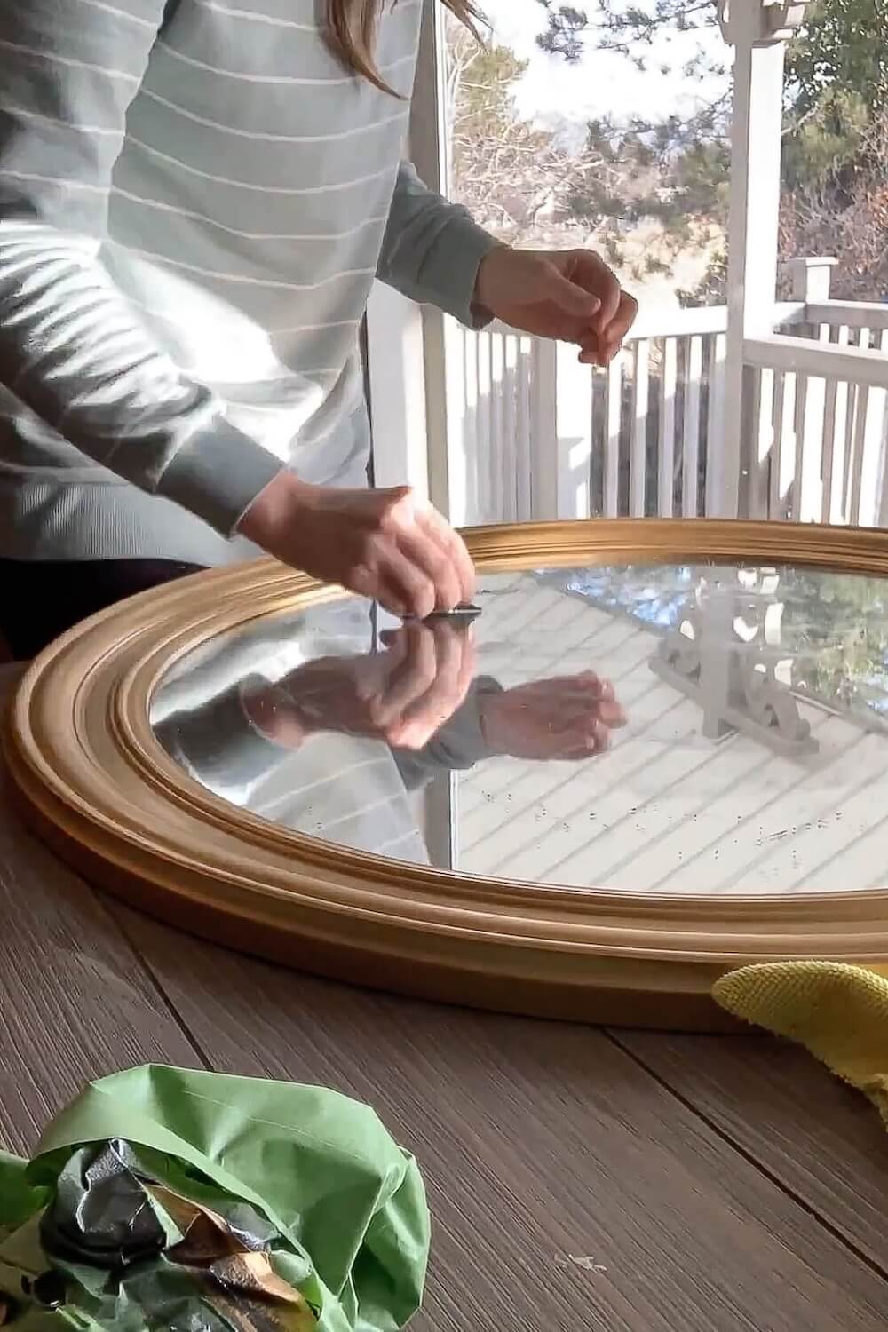 Cleaning overspray from mirror glass with razor