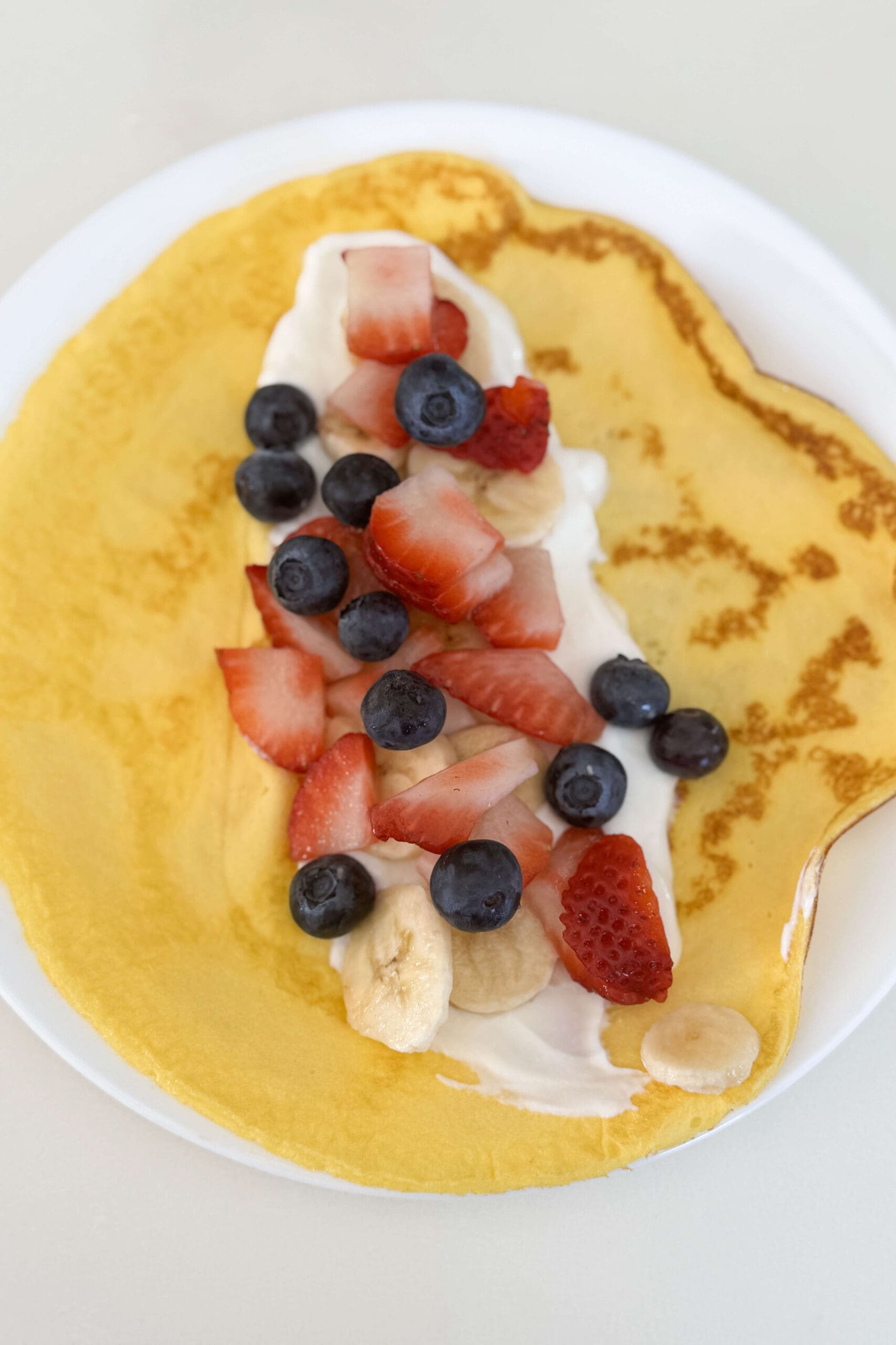 cottage cheese and egg pancake topped with berries and yogurt
