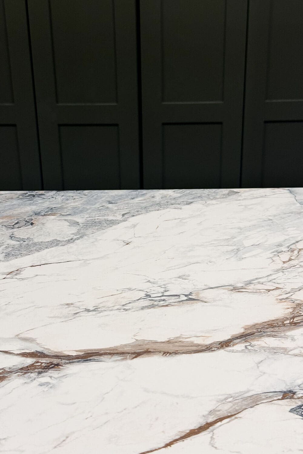 Finished DIY faux marble countertop paired with green cabinets