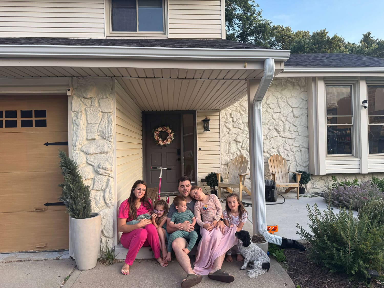 Family sitting on front porch during DIY home remodel project with updated curb appeal