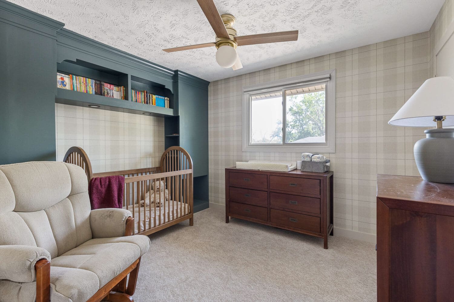 Plaid wallpaper nursery after DIY home renovation with custom built-ins and crib styling.