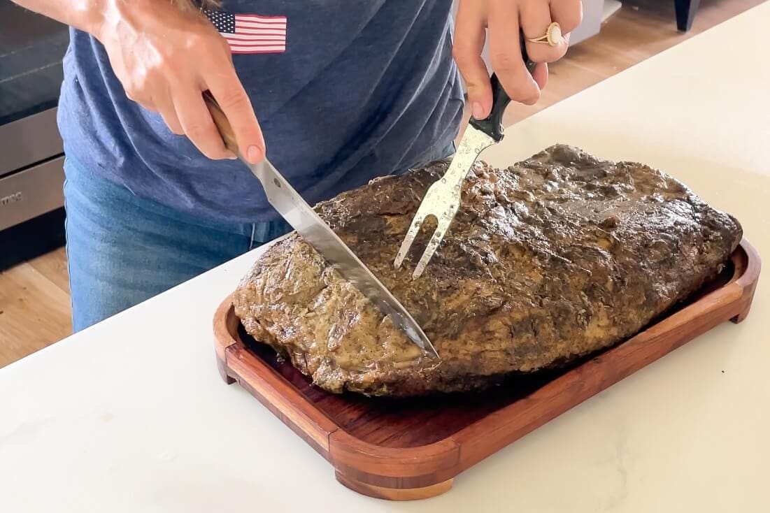 Slicing smoked brisket, a flavorful meat option for your game day food spread.