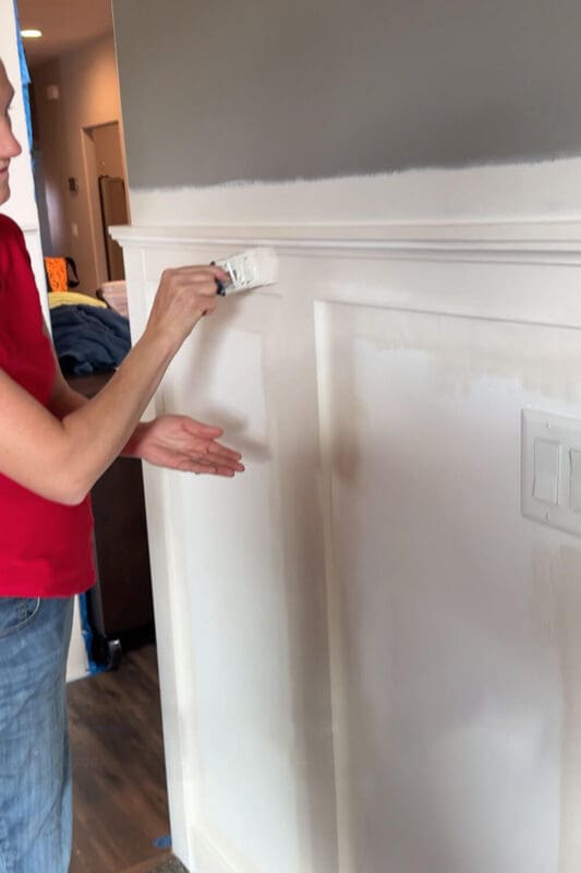 Close-up of brushing and cutting in paint on board and batten before smoothing with a foam roller in a quick makeover.