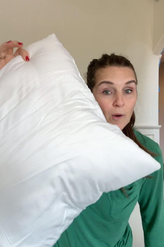 Sizing up a throw pillow insert for a formal living room, using a larger insert to make covers look fuller and more plush.